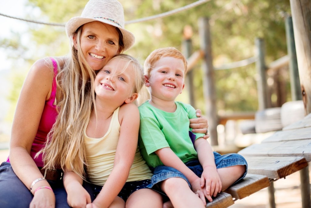Single mother enjoying time outdoors with her children after successfully exiting an unaffordable timeshare.