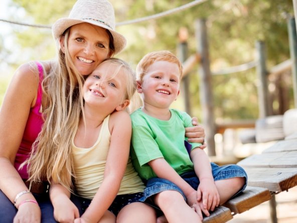 Single mother enjoying time outdoors with her children after successfully exiting an unaffordable timeshare.